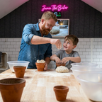Dad with ginger beard and his son pressing dough into a clay pot