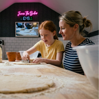 Mum and daughter cutting shapes from rolled dough, low side angle